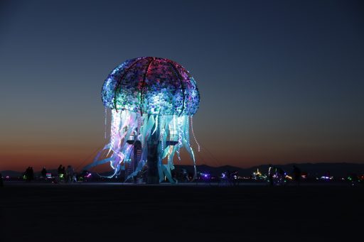 The illuminated "Jellyfish" art installation glows with vibrant colors against the twilight sky at Burning Man in Black Rock City, Nevada. T