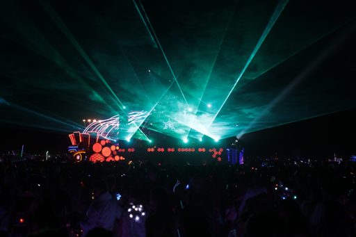 Green lasers cut through the night sky over a crowd gathered for a performance at the Black Rock Desert, Nevada, during the 2017 Burning Man
